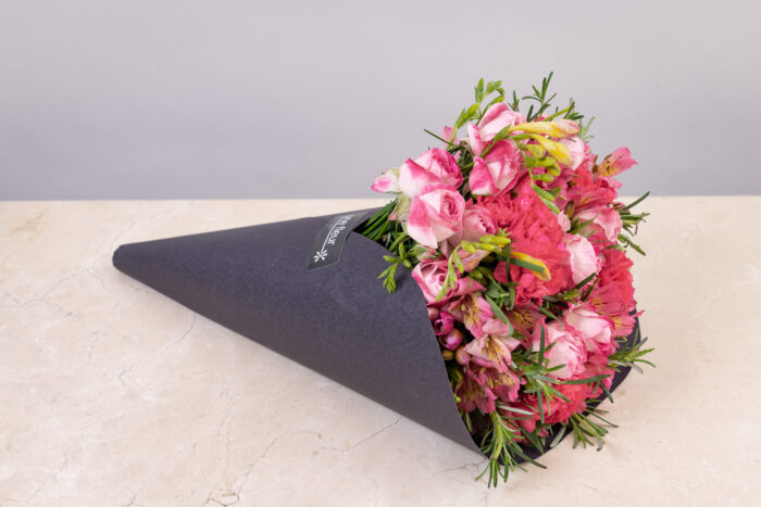 Buquê de flores rosas premium com rosas, astromélias e folhagens finas embalado em cone preto sofisticado, ideal para presentear parceira com elegância e exclusividade.
