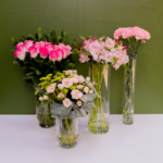 Arranjos florais elegantes com rosas, astromélias, mini rosas e cravos em vasos de vidro, decoração premium para festas e eventos sofisticados.