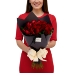 rosas vermelhas nobres , embaladas em papel preto elegante e laço sofisticado, assinatura Une Fleur dans la Ville.