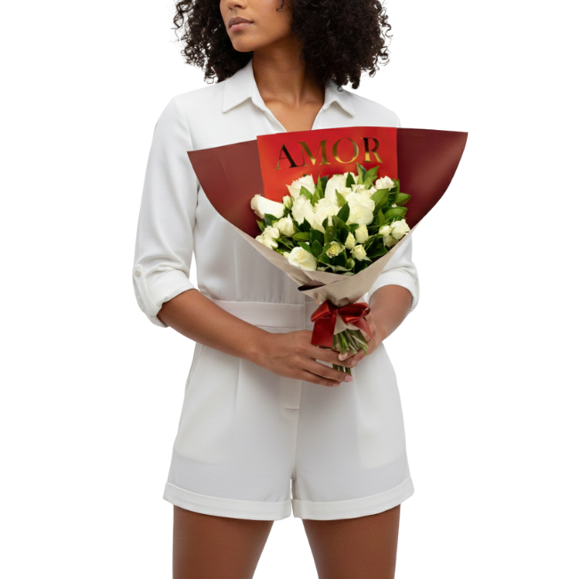 Mulher segurando um bouquet de flores brancas premium e folhagens sofisticadas, embalado em papel bermelho com laço vermelho, da Une Fleur dans la Ville