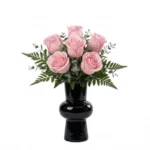 Arranjo de rosas cor de rosa em vaso preto elegante com folhagens verdes, ideal para presente sofisticado e decoração moderna