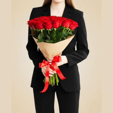 Mulher vestindo terno preto casual segurando um bouquet de 12 rosas vermelhas premium embaladas em papel kraft com laço vermelho.