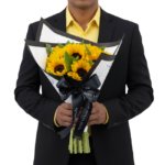 Buquê Lily Rose de girassóis frescos com embalagem sofisticada preta e branca, laço exclusivo Une Fleur dans la Ville, ideal para presentear com elegância.