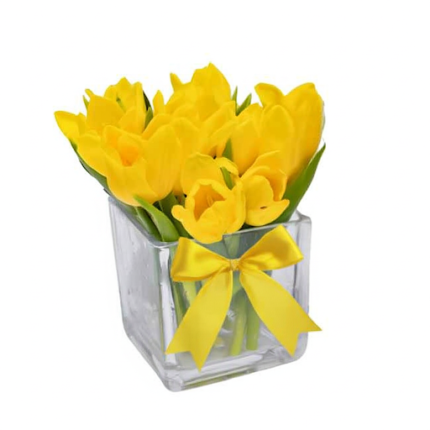 Arranjo de tulipas amarelas frescas em vaso de vidro transparente com laço rosa decorativo, ideal para presente e decoração