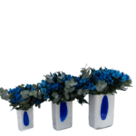 Trio de arranjos florais luxuosos com alstroemérias azuis e eucaliptos em vaso de vidro polonês artesanal.