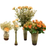 Kit de vasos portugueses em vidro caramelo com arranjos de cravos alaranjados e flores complementares, ideal para decoração de casa, festas e eventos.