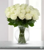 Arranjo de rosas brancas com ruscus em vaso de vidro português Dámaso, modelo Roma, presente sofisticado da Une Fleur dans la Ville.