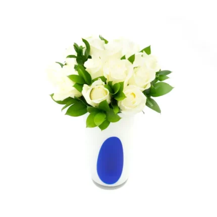 Arranjo floral luxuoso com rosas brancas e ruscus em vaso de vidro polonês artesanal.