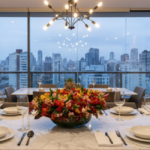 Arranjo de alstroemérias coloridas em vaso de vidro como centro de mesa em jantar sofisticado, com vista urbana de São Paulo ao fundo, decoração elegante e contemporânea.