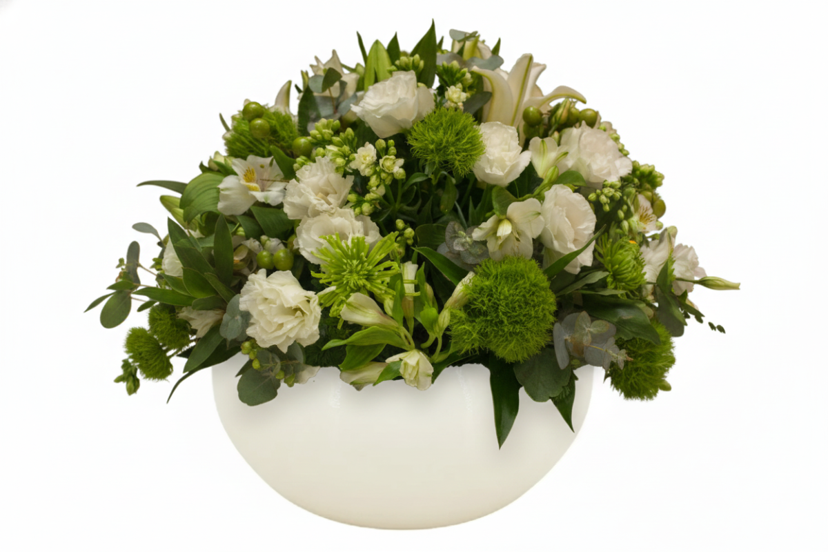 Centro de mesa sofisticado com flores brancas e verdes em vaso de vidro fosco, ideal para decoração de Réveillon elegante.