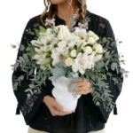 Arranjo elegante de flores brancas em vaso moderno branco com folhagens de eucalipto