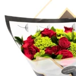 Bouquet premium com rosas vermelhas colombianas embalado em papel elegante da Une Fleur dans la Ville para presente romântico em São Paulo.