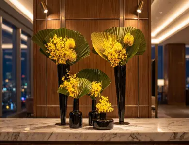 arranjos de flores em um vaso preto em cima de uma mesa de recepção corporativa.